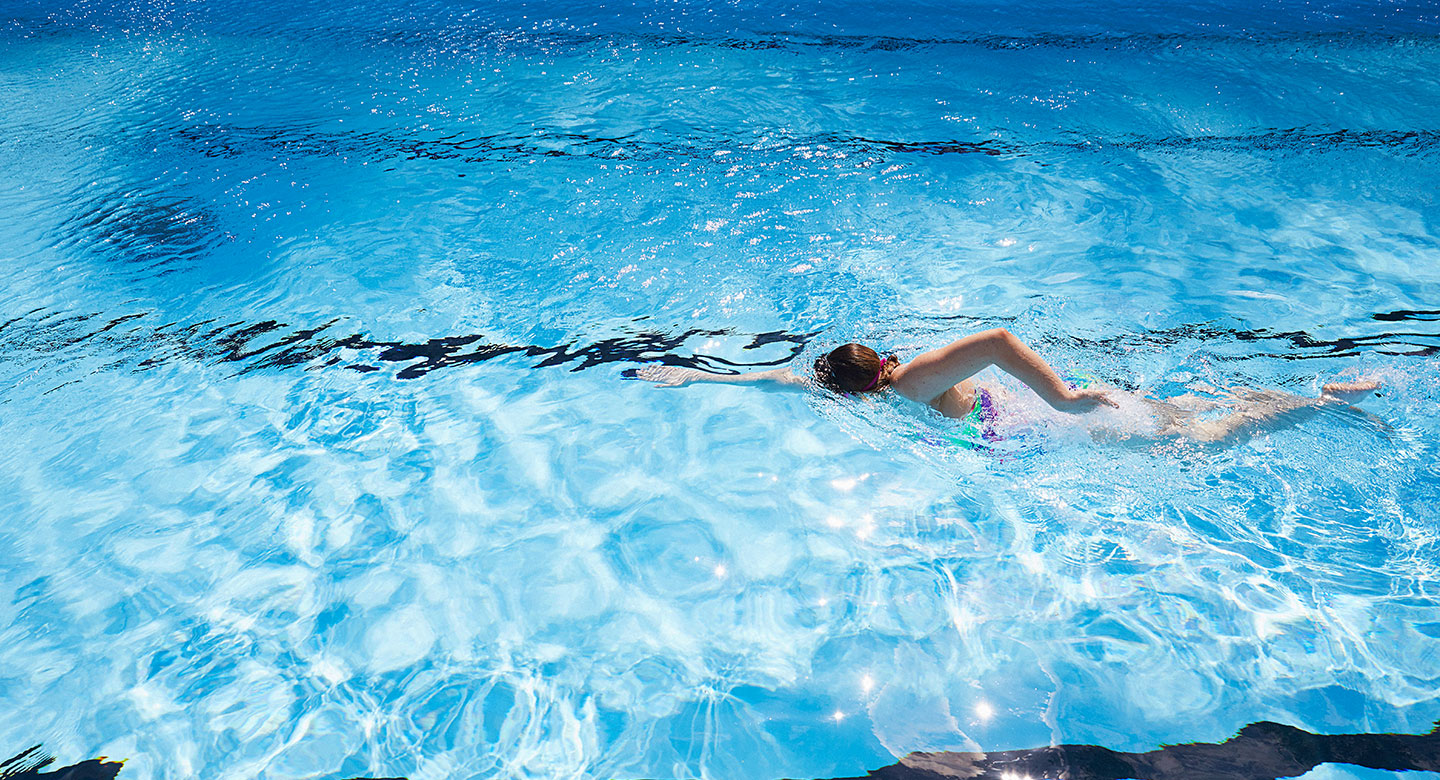 Image of a lady swimming in the outdoor pool at David Lloyd Royal Berkshire